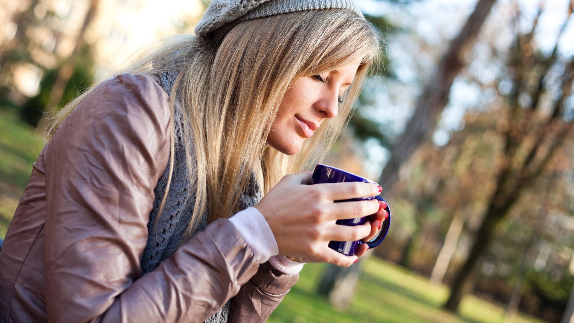 woman outside holding purple mug of tea